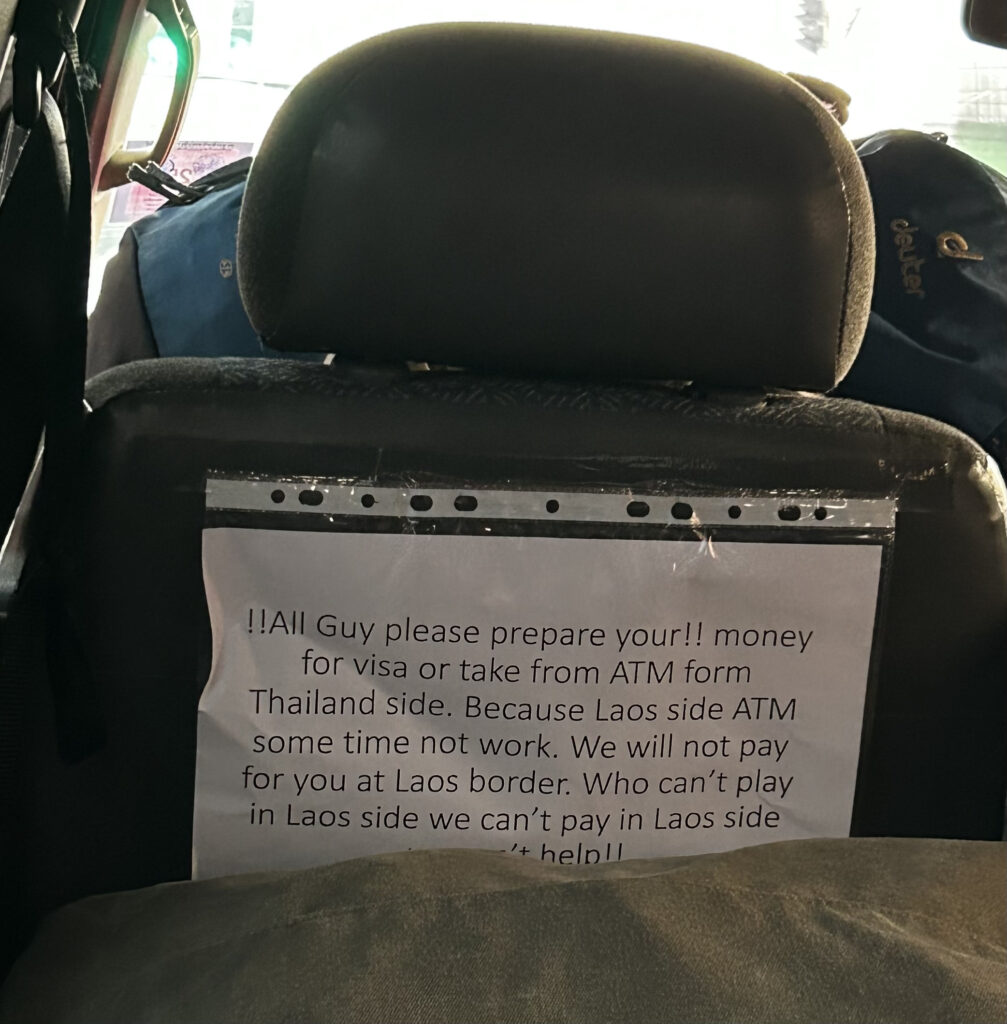  Sign in the minivan reminding passengers to have enough cash on them for the visa fee while entering Laos